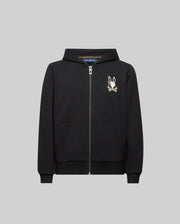 The Psycho Bunny KIDS WADE CORD PATCH ZIP HOODIE (KT0500016) is a black zip-up hoodie crafted from a premium cotton blend, featuring a hood, front pockets, and an embroidered bunny skull logo on the left chest. Displayed on a plain grey background.