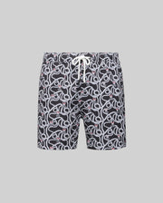 The Psycho Bunny MENS CYRUS ALL OVER PRINT SWIM TRUNK (MB1000004) features a black quick-dry seersucker fabric with an all-over white snake pattern, red accents, and a white waist drawstring, shown on a plain gray background.