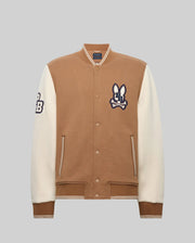 The Psycho Bunny MENS WADE KNIT BOMBER (MO1100020) is a tan and white varsity jacket with a tan body, white sleeves, striped cuffs and hem, snap buttons, and "CB" bunny logo patches on the chest and left sleeve.
