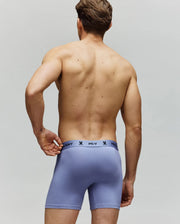 A shirtless man faces away from the camera, wearing Psycho Bunny MENS 3 PACK BOXER BRIEF - MO1400006 in light purple cotton-modal with a comfy logo waistband featuring a repeated small icon.