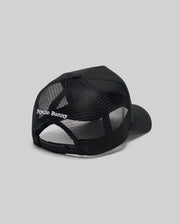 The Psycho Bunny MENS GLENN TRUCKER CAP (MO1500004) features black mesh, an adjustable snapback, and "Psycho Bunny" embroidered in white above the back opening. Shown against a plain gray background.