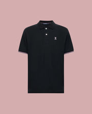 The Psycho Bunny MENS ARCHIVE CLASSIC BUNNY PIQUE POLO (MT0100010) is a black Pima cotton short-sleeve polo with a collar, two buttons, white and pink trim accents, and a white embroidered logo on the chest. Displayed on light pink.