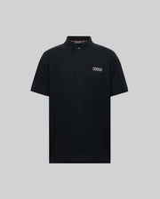 The Psycho Bunny MENS AXTON PIQUE POLO (MT0100011) is a plain black Pima cotton short-sleeve polo with a collar, three buttons, and a jacquard-woven logo patch on the left chest, shown against a light gray background.