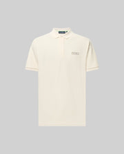 The Psycho Bunny MENS AXTON PIQUE POLO (MT0100011) is a cream Pima cotton short-sleeve polo with a small jacquard logo patch on the left chest and a concealed button placket, shown against a light grey background.