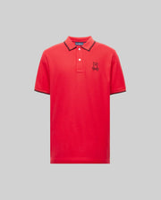 The Psycho Bunny MENS JUDE PIQUE POLO (MT0100012) is a red Pima cotton short-sleeve shirt with a collar, three buttons, and a black embroidered Bunny logo on the left chest, shown on a plain light gray background.
