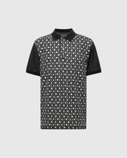 The Psycho Bunny MENS BECKETT PIQUE POLO (MT0100022) is a black short-sleeve Pima cotton shirt with solid black collar and sleeves, featuring a white and gray geometric front pattern on black, shown on a light gray background.
