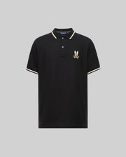 The Psycho Bunny MENS WADE PIQUE POLO (MT0100044) is a black Pima cotton polo for men, featuring white and beige colorblock trim on the collar and sleeves, plus an embroidered eagle crest logo on the left chest. Displayed on a plain gray background.