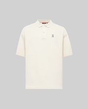 The Psycho Bunny MENS HENRY OVERSIZED FIT POLO (MT0100104) is a soft Pima cotton jersey shirt in plain off-white, with short sleeves, a collar, button placket, and small embroidered bunny logo on the chest. Displayed on a light gray background.