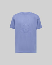 The Psycho Bunny MENS REMY GRAPHIC TEE (MT0200059) is a light purple Pima cotton short-sleeve shirt featuring an embossed bunny logo above crossed bones on the chest, shown on a plain light background.