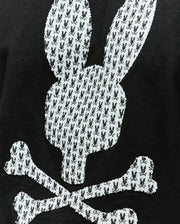 The Psycho Bunny MENS TALON GRAPHIC TEE (MT0200179) is a regular fit, 100% cotton black tee featuring a white Bunny skull and crossbones graphic with smaller rabbit icons.