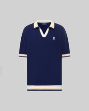 The Psycho Bunny MENS CARTER JOHNNY COLLAR KNIT POLO (MT0400093) is a navy blue cotton short-sleeve shirt with white and beige striped collar, cuffs, and hem, plus a white embroidered bird logo on the left chest. Regular fit.