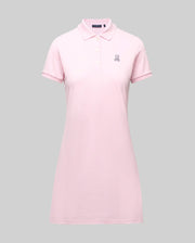 The Psycho Bunny WOMENS POLO DRESS - WO2000003 is a light pink Pima polo dress with a feminine fit, collar, three Mother-of-Pearl buttons, and a small embroidered bunny logo on the left chest, shown on a plain gray background.