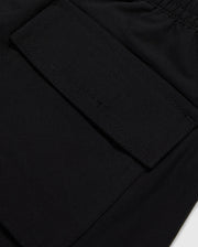 Close-up image of a black fabric pocket with a flap and Velcro closure. The pocket is attached to the KIDS MALTA HYDROCHROMIC SWIM TRUNK - B0W321B2SW by Psycho Bunny, adorned with a playful bunny pattern, and the stitching around the edges is clearly visible. The fabric appears to be smooth and durable.