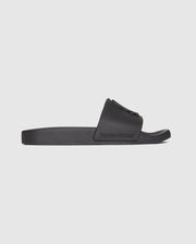 The MENS BUNNY LOGO SLIDES - B6A910U1FT by Psycho Bunny are black rubber pool slide sandals with a wide strap featuring embossed Psycho Bunny logos. The flat, textured sole provides grip and comfort, while the molded footbed ensures a perfect fit. The words "Psycho Bunny" are prominently embossed on the side of the strap against a plain white background.