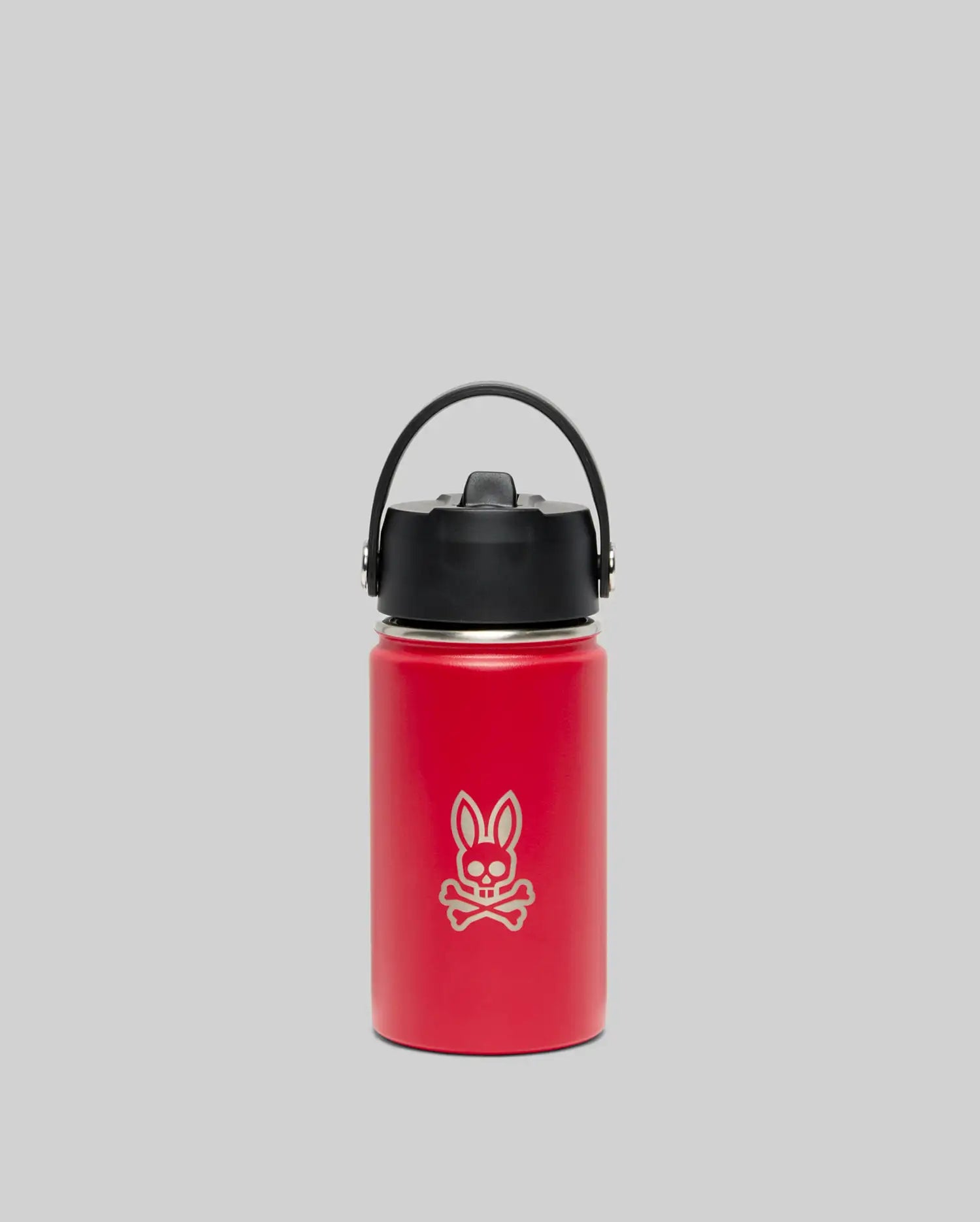 The Psycho Bunny KIDS PSYCHO BUNNY WATER BOTTLE - B0A375E200 is a red insulated stainless steel bottle with a black lid and handle, featuring a white cartoon bunny and crossbones design, shown on a plain gray background.