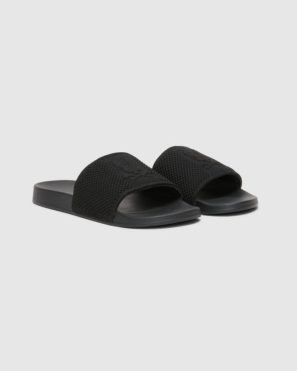 A pair of black KIDS KNIT SLIDES (B0A377F200) by Psycho Bunny on a plain background, featuring textured straps, smooth soles, and molded footbed for casual wear.