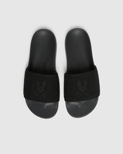 A pair of black Psycho Bunny KIDS KNIT SLIDES - B0A377F200, featuring a textured strap with an embroidered stylized rabbit head logo and a molded footbed for comfort, are placed side by side on a light gray background.