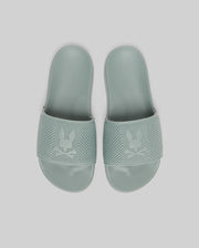 Psycho Bunny KIDS KNIT SLIDES - B0A377F200 in light green feature knit textile, textured straps with a bunny and crossbones logo, and an ergonomically molded footbed, displayed against a plain light background.