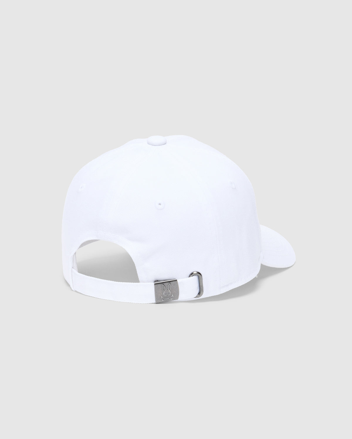 The KIDS CLASSIC BASEBALL CAP - B0A816A1HT by Psycho Bunny features a white cap with an adjustable silver buckle and an embroidered Bunny logo. With its back facing the viewer and set against a light gray background, this piece exudes timeless style and practicality.