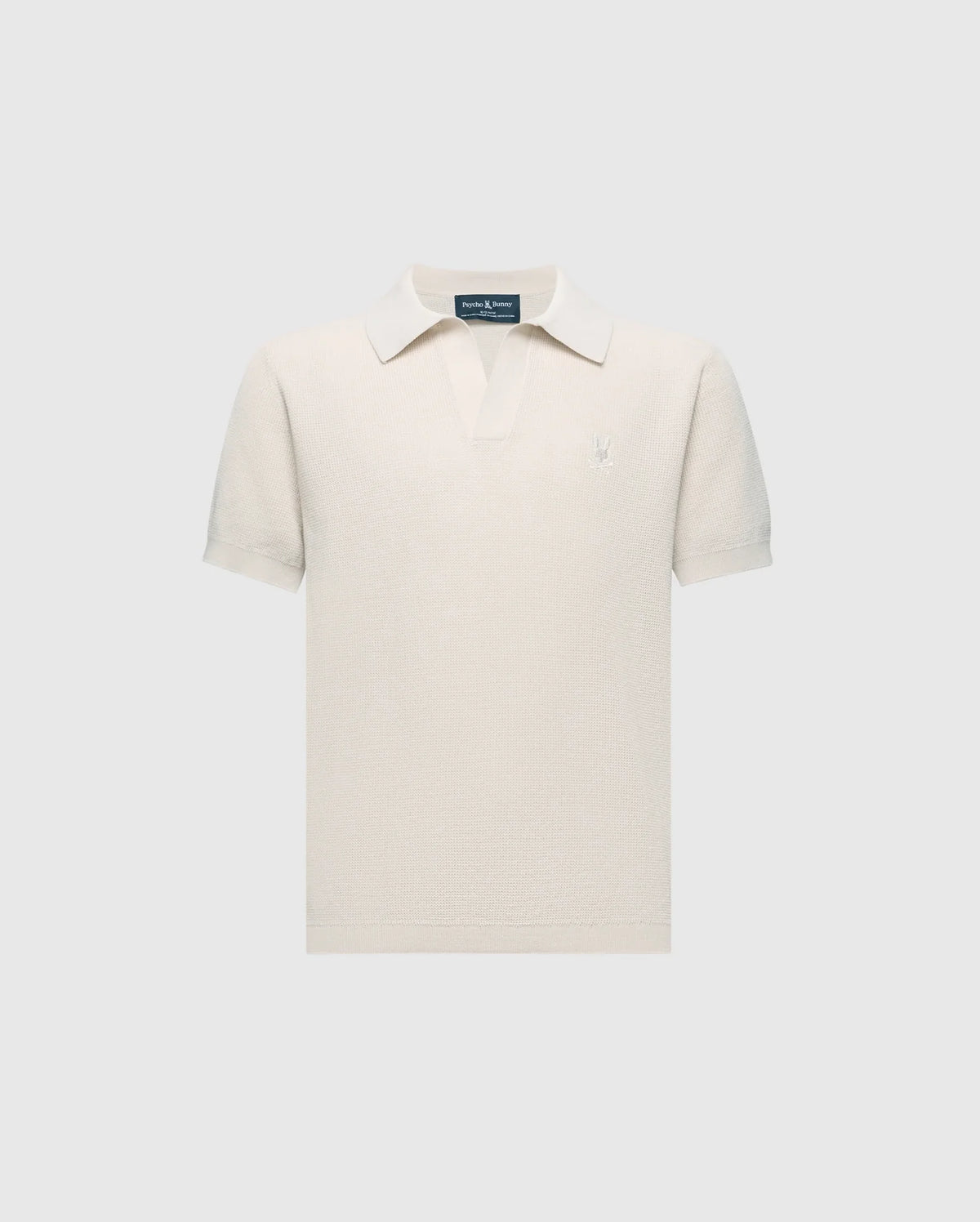 The KIDS LEETON JOHNNY COLLAR KNIT POLO - B0E562F200 by Psycho Bunny is a cream-colored terry cloth shirt featuring short sleeves, a small collar, and an embroidered bunny logo on the left chest. Made from breathable cotton with a textured look, it’s set against a plain backdrop.