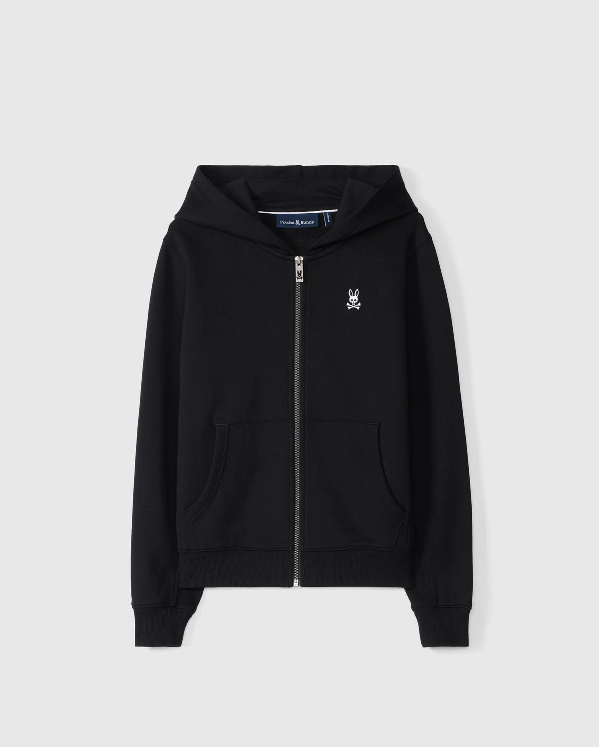 The KIDS LEVY ZIP FLEECE HOODIE - B0H720D200 by Psycho Bunny features a black zip-up design with a small white bunny logo on the left chest. Constructed from 100% cotton French terry, it includes front pockets and a hood, showcased against a plain white background.