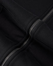 Close-up image of the Psycho Bunny KIDS LEVY ZIP FLEECE HOODIE - B0H720D200 in black, highlighting the metal zipper and the seam where the hood attaches to the main body of the garment. The thick, fleece-lined fabric appears soft and warm, ideal for little ones.