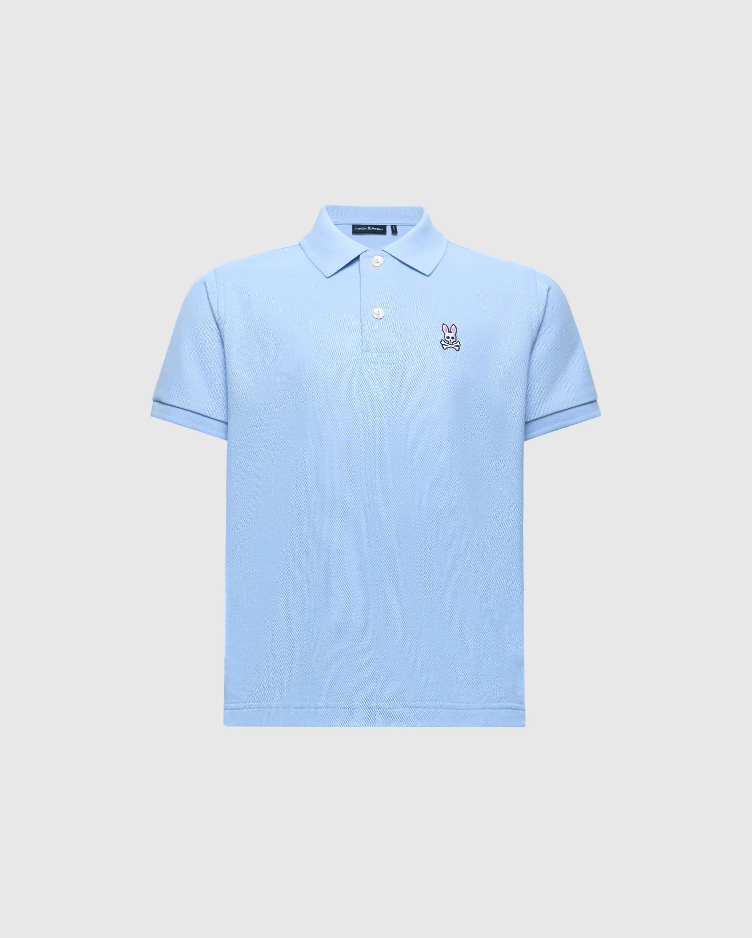 The Psycho Bunny KIDS CLASSIC PIQUE POLO (B0K001B200) is a light blue shirt with short sleeves, a folded collar, and button-up neckline. Made from Pima cotton, it features an embroidered bunny logo on the left chest against a plain gray background.