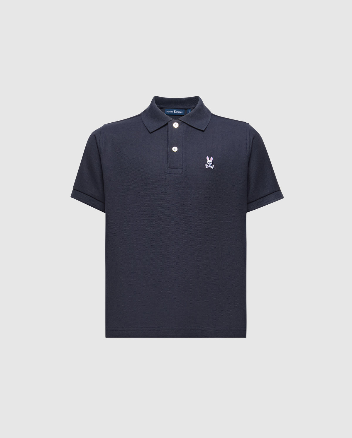 The Psycho Bunny KIDS CLASSIC PIQUE POLO SHIRT (B0K001CRPC) is a navy blue Pima cotton polo featuring short sleeves, a collared neckline with two white buttons, and an embroidered white logo on the left chest, shown against a light background.