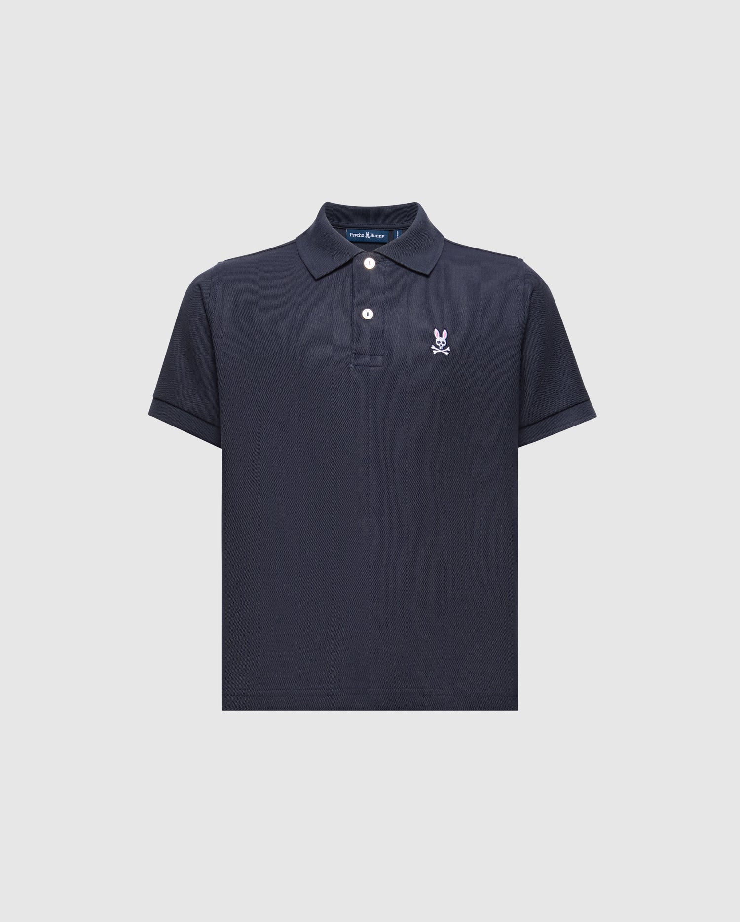The Psycho Bunny KIDS CLASSIC PIQUE POLO SHIRT (B0K001CRPC) is a navy blue Pima cotton polo featuring short sleeves, a collared neckline with two white buttons, and an embroidered white logo on the left chest, shown against a light background.