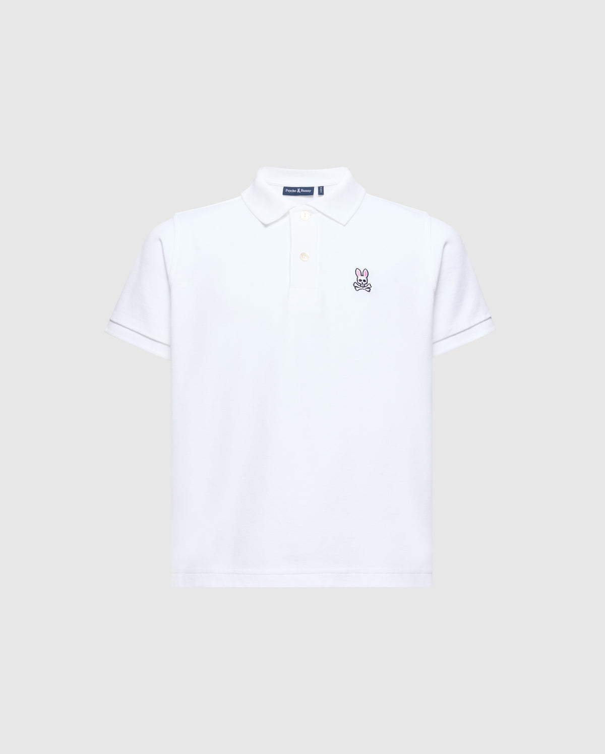 The Psycho Bunny Kids Classic Pique Polo Shirt (B0K001CRPC) is a white short-sleeved polo shirt made from soft Pima cotton. It features an embroidered rabbit logo on the left chest and has a classic collar with a button-up placket, all set against a light grey background.