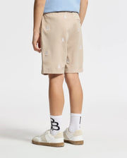 A person is seen from the rear dressed in a light blue shirt, the KIDS ALL OVER WILLIS STRETCH TENCEL SHORT - B0R559F200 by Psycho Bunny with subtle white globe motifs, and white sneakers featuring brown soles against a plain white backdrop.