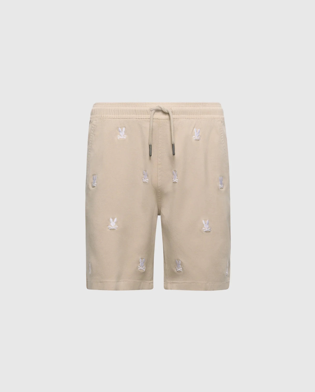 The KIDS ALL OVER WILLIS STRETCH TENCEL SHORT by Psycho Bunny, B0R559F200, features beige fabric with an elastic waistband, drawstring, and small white embroidered motifs. Its stretch Tencel blend offers comfort and sophistication against a plain white background.