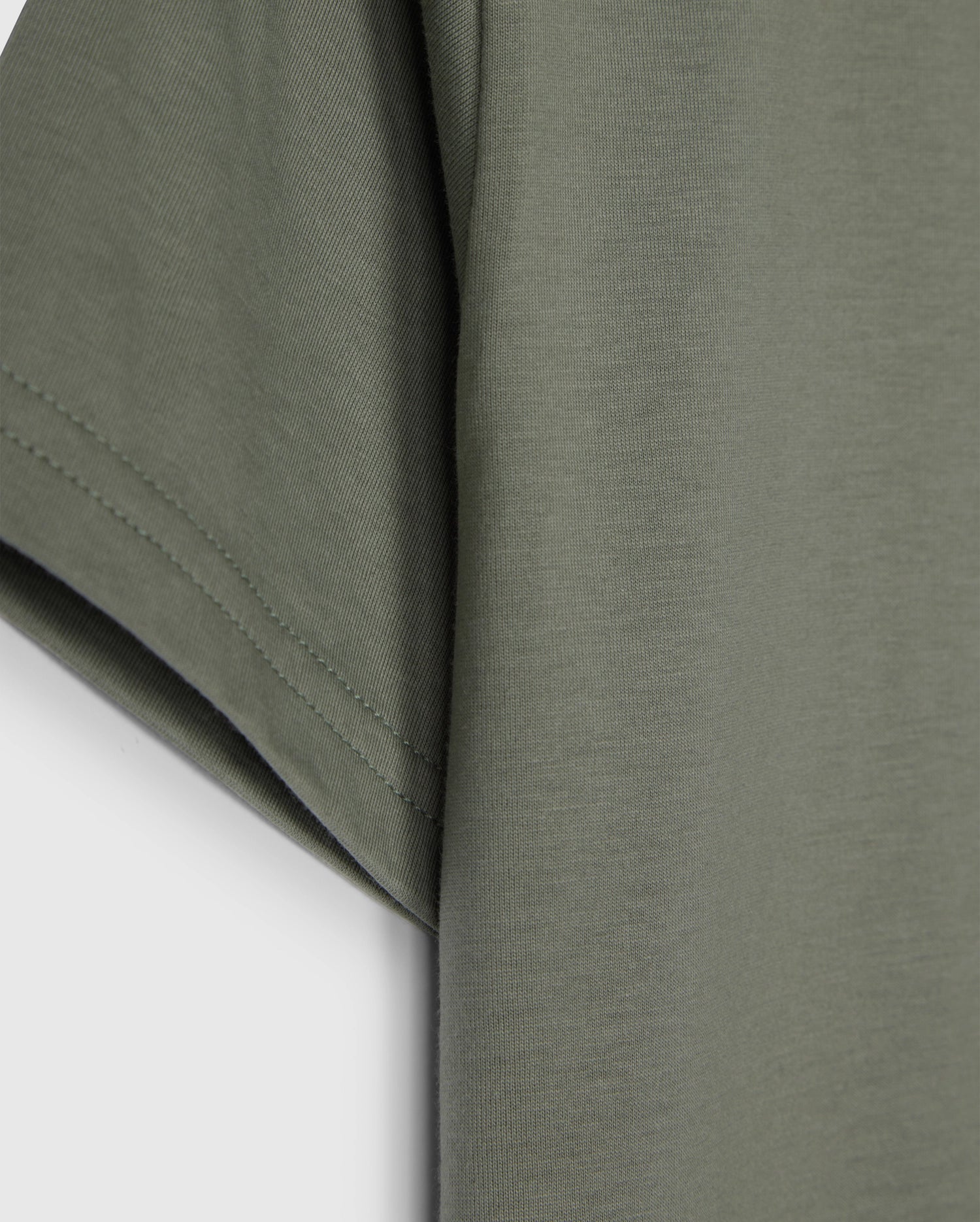 The KIDS CLASSIC CREW NECK TEE - B0U014B200 by Psycho Bunny, in olive green, showcases sleeve and side details on a plain white background. Made from 100% Pima cotton, its texture and stitching make it an ideal back-to-school choice.