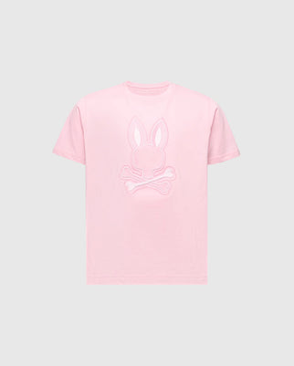 The KIDS NEW CASTLE EMBROIDERED GRAPHIC TEE - B0U415F200 by Psycho Bunny features a pink tee with a bunny head and skull and crossbones embroidery on the chest, all in premium Pima cotton set against a gray background.