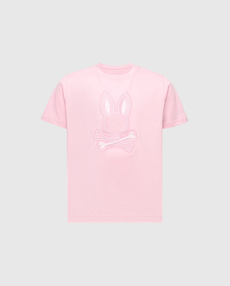 The KIDS NEW CASTLE EMBROIDERED GRAPHIC TEE - B0U415F200 by Psycho Bunny features a pink tee with a bunny head and skull and crossbones embroidery on the chest, all in premium Pima cotton set against a gray background.
