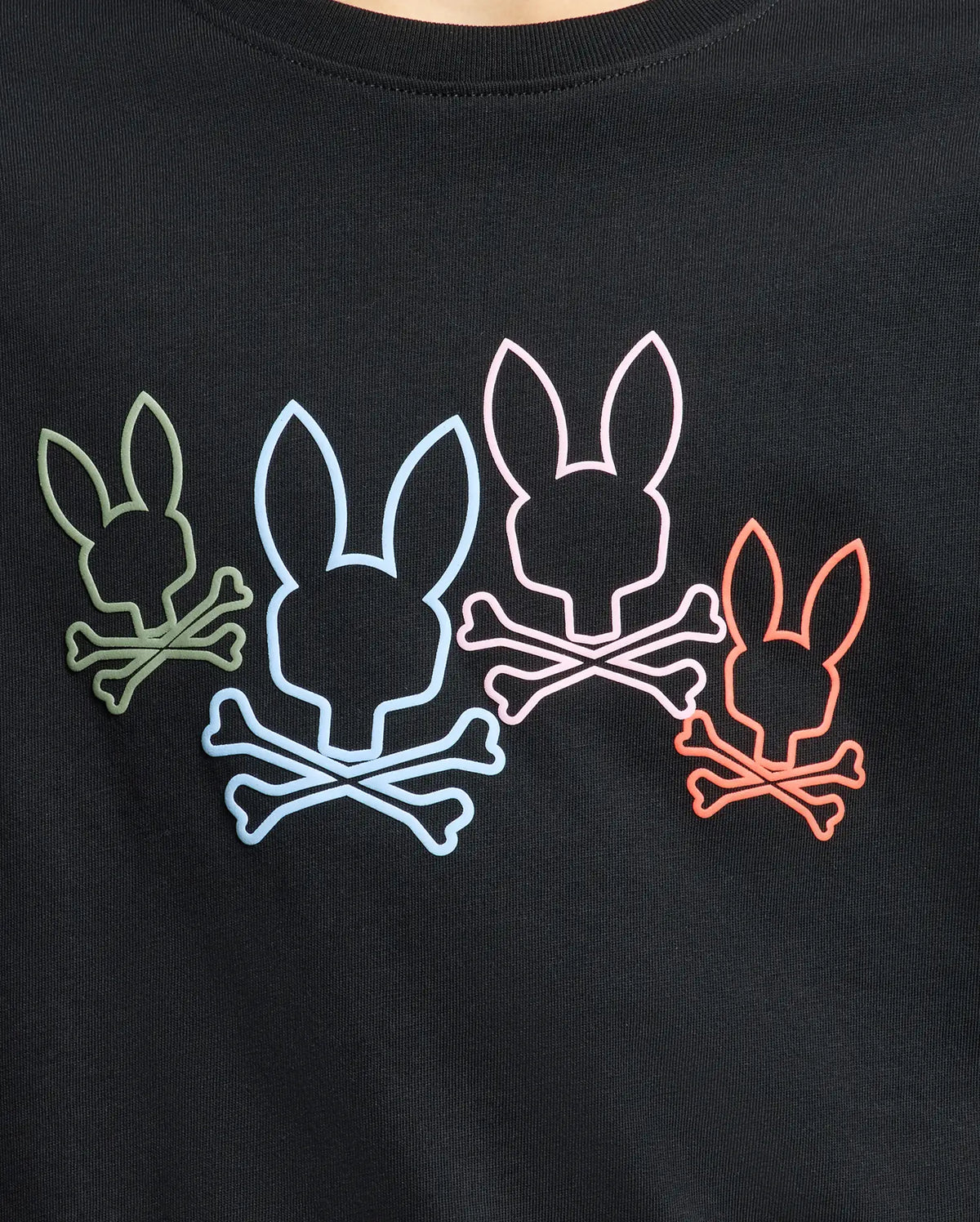 The Psycho Bunny KIDS SILVERDALE GRAPHIC TEE - B0U499F200 showcases four stylized bunny skulls in green, blue, pink, and red atop crossbones on black fabric. It features an eco-friendly water-based print method for a striking look.
