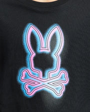 The KIDS ANDROS GRAPHIC TEE - B0U525F200 by Psycho Bunny is a black Pima Cotton t-shirt crafted in Peru with a striking bunny design featuring a pink and blue neon rabbit head above crossed bones, enhanced by a luminous glow effect.