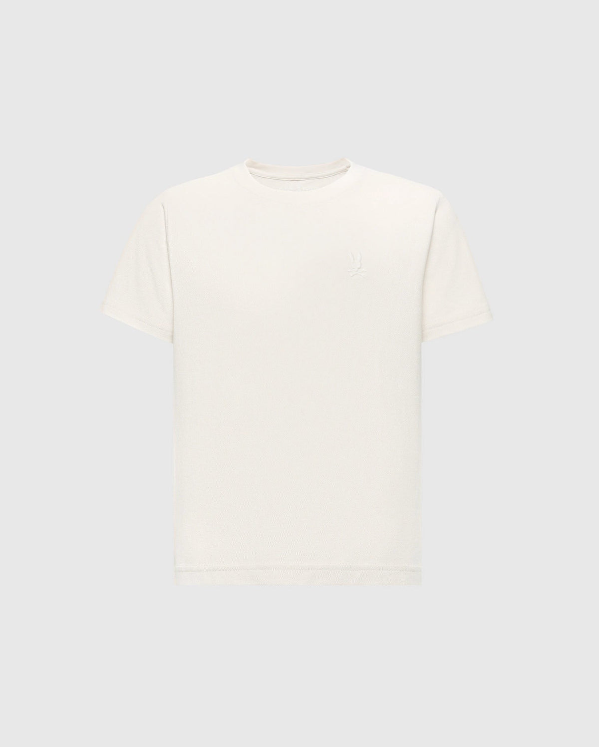 The KIDS TAYLOR PIQUE TEE by Psycho Bunny is an off-white Pima cotton T-shirt featuring a round neck, short sleeves, and an embossed logo on the upper left chest. It is displayed on a light gray background, highlighting its classic style.