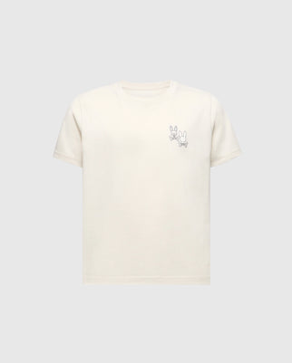 The Psycho Bunny KIDS ELLIOT FRONT BACK GRAPHIC TEE (B0U605F200) is a light beige Pima cotton shirt featuring an eco-friendly water-based print of a simple cartoon rabbit line drawing on the upper left, set against a plain grey background.