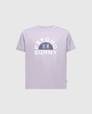 The KIDS GOLDIE GRAPHIC TEE - B0U606F200 by Psycho Bunny showcases a lavender design with bold white "Psycho Bunny" letters, featuring a centered stylized bunny and crossbones. Made from soft Peruvian Pima cotton, it offers a comfortable and relaxed fit.