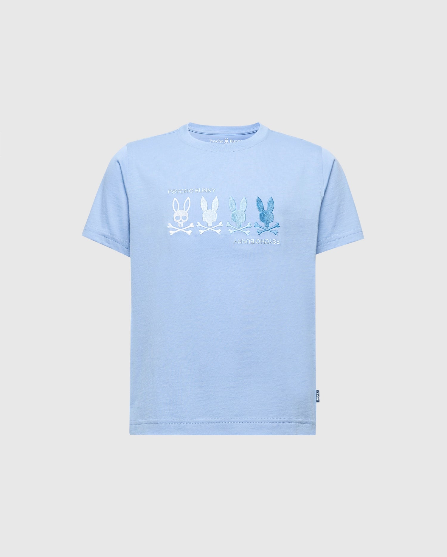 The KIDS OCEANIA EMBROIDERED GRAPHIC TEE - B0U607F200 from Psycho Bunny is a light blue Pima Cotton shirt featuring retro line-drawn bunnies in various shades above crossed bones, with 