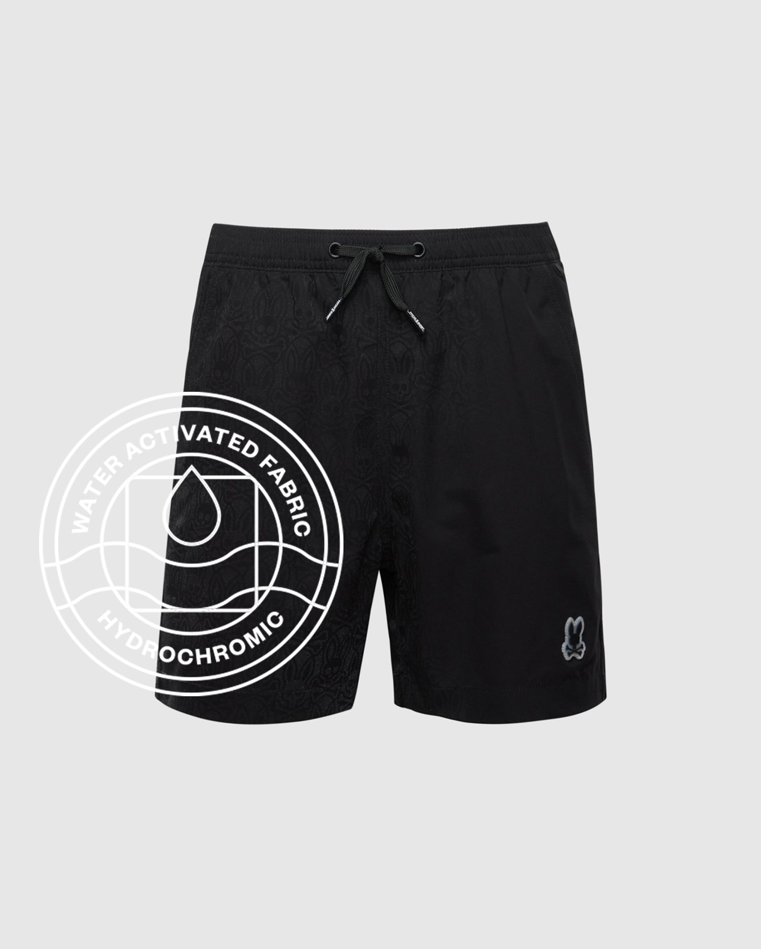 The KIDS SAMOS HYDROCHROMIC SWIM TRUNK by Psycho Bunny features quick-dry fabric, a subtle all-over pattern, elastic drawstring waistband, and an embroidered character. Overlay text: “Water Activated Fabric - Hydrochromic.”.