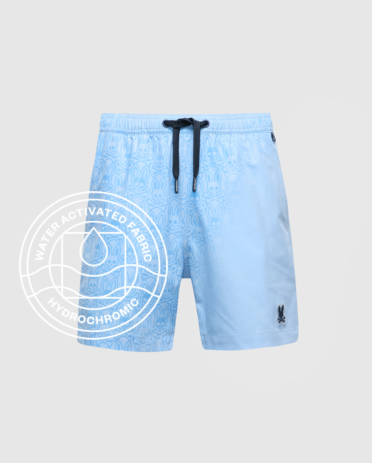 The KIDS SAMOS HYDROCHROMIC PRINTED SWIM TRUNK by Psycho Bunny features a light blue pattern, black drawstring, and bunny logo. Water-activated Hydrochromic fabric reveals hidden designs—ideal with your waterproof bag for pool days.