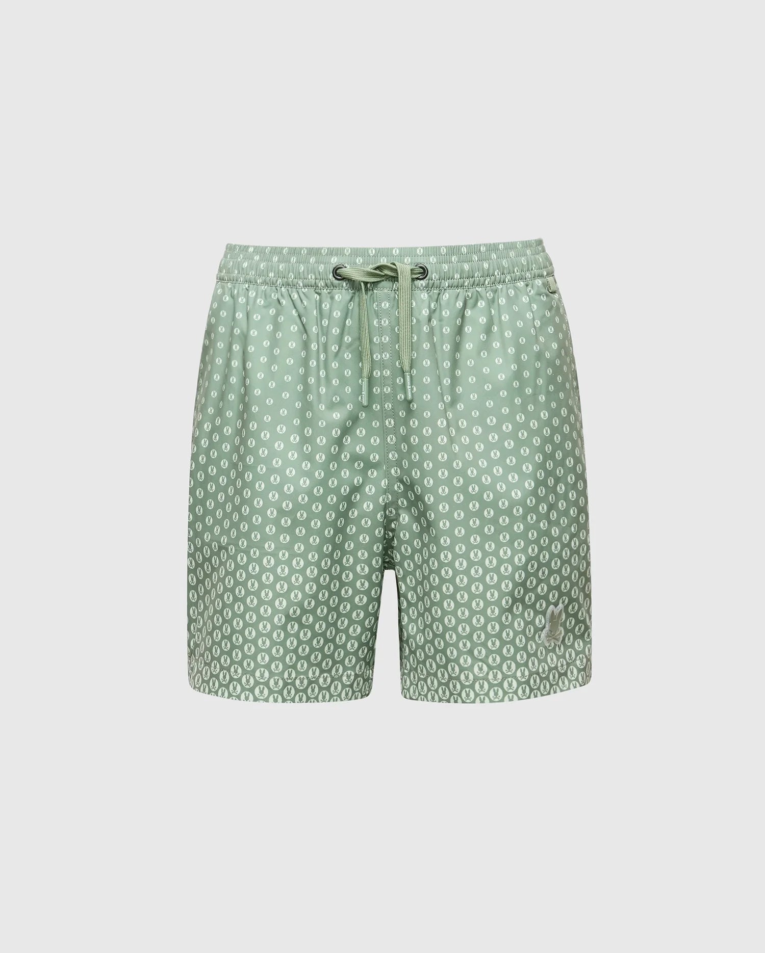 The Psycho Bunny KIDS BENDIGO ALL OVER PRINTED SWIM TRUNK (B0W619F200) features light green quick-dry fabric with white circular dots, an elastic waistband, and a drawstring tie. Displayed on a plain white background.
