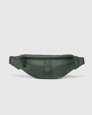 The Psycho Bunny MENS CROSS BODY BAG - B6A181E200 is a green travel bag for men, featuring a top zipper pocket and an embroidered rabbit and crossbones logo on the front. Made from smooth, semi-glossy nylon, it includes an adjustable strap for convenience.