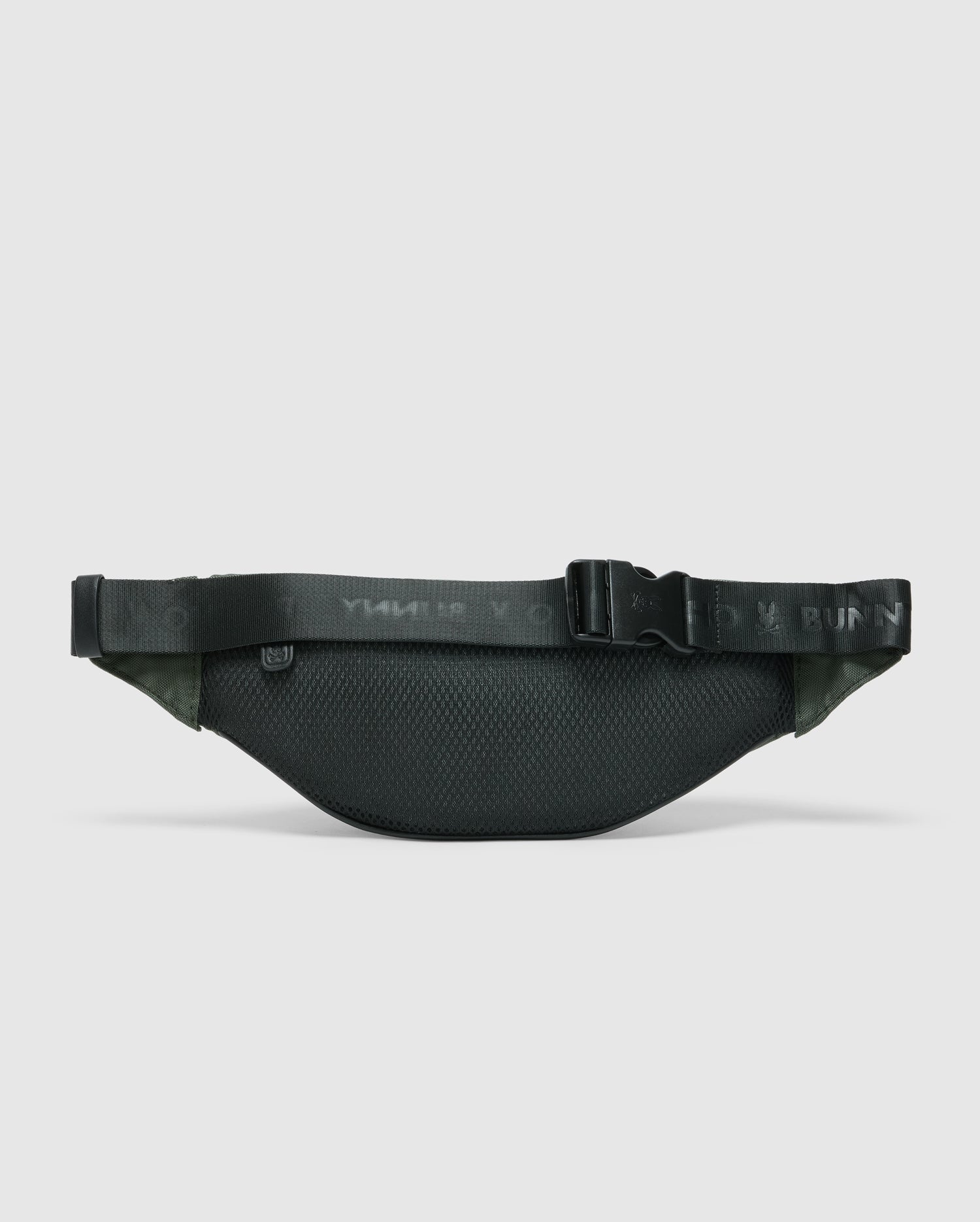 The Psycho Bunny MENS CROSS BODY BAG - B6A181E200 is a dark green textured nylon fanny pack featuring a black adjustable strap and a plastic buckle, displayed on a light gray background. It's perfect for men seeking convenience during travel.