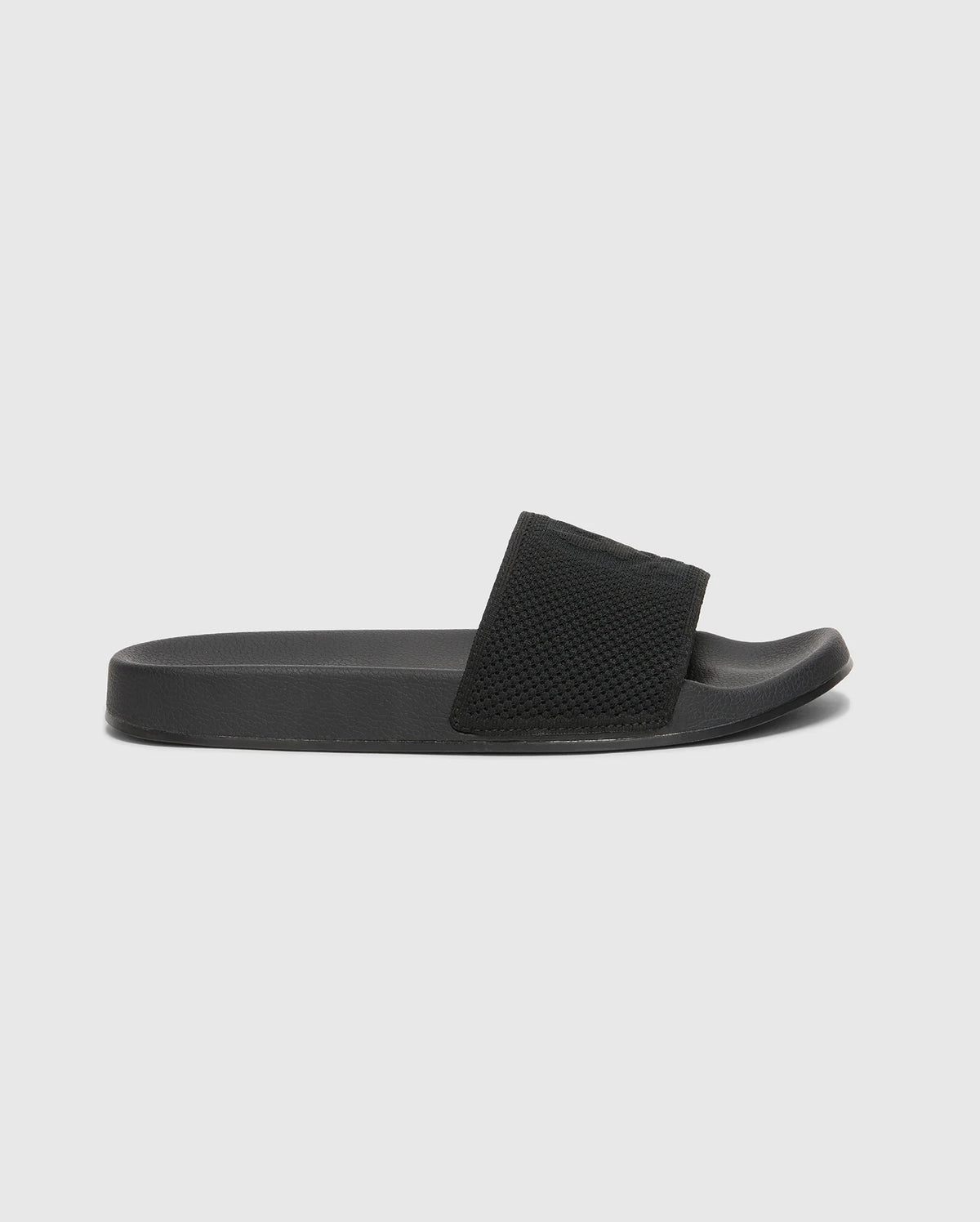 The Psycho Bunny MENS KNIT SLIDES - B6A474F200 are black slide sandals with textured straps, flat soles, and molded footbeds for comfort. Displayed against a white background, they feature an open toe design.