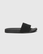 The Psycho Bunny MENS KNIT SLIDES - B6A474F200 are black slide sandals with textured straps, flat soles, and molded footbeds for comfort. Displayed against a white background, they feature an open toe design.