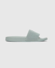The Psycho Bunny MENS KNIT SLIDES - B6A474F200 are light green pool slide sandals with a textured knit strap, open toe, and ergonomically molded footbed, shown in side profile against a plain white background.
