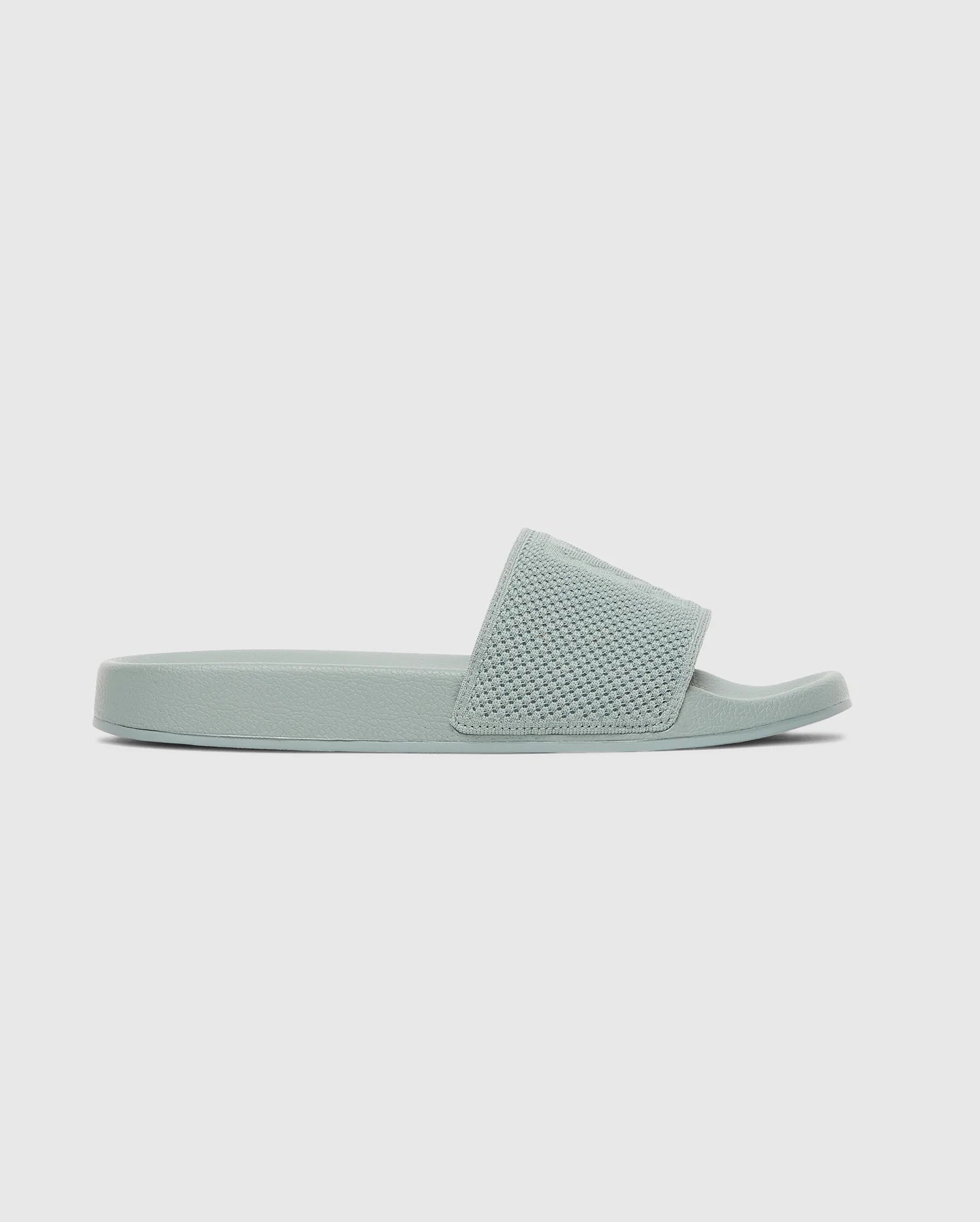 The Psycho Bunny MENS KNIT SLIDES - B6A474F200 are light green pool slide sandals with a textured knit strap, open toe, and ergonomically molded footbed, shown in side profile against a plain white background.